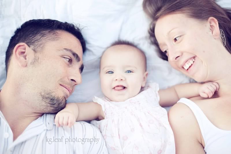 little girl laying with mom and dad